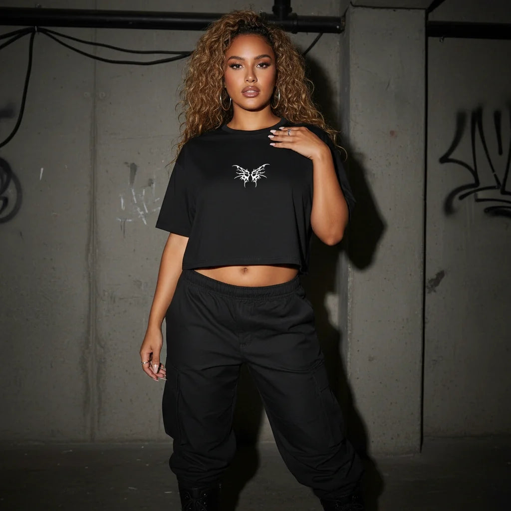 Damen Oversize Crop Top mit Tribal-Print vor Betonwand