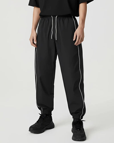 Reflective Nightflow broek in zwart, relaxed gedragen, ideaal voor techno en rave.