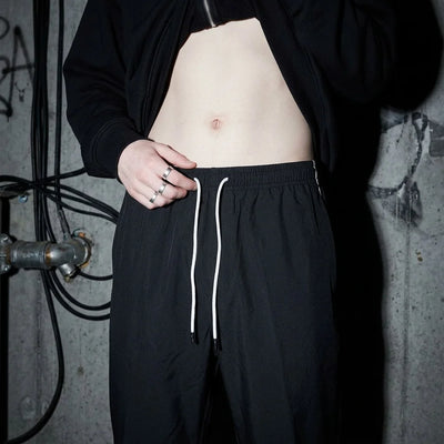 Close-up van de Reflective Nightflow broek, zwarte stof, perfect voor festivals.