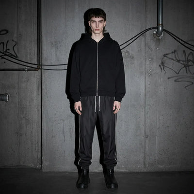Model van voren in Reflective Nightflow broek, zwart, ideaal voor technoevents.