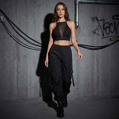 Shadow Mesh Top in Schwarz, Model posiert vor urbanem Hintergrund, Festival-Mode.